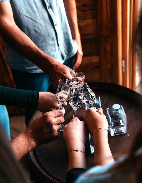 Fünf Personen stoßen mit einem Schnapsglas an